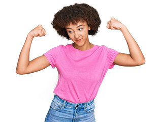 Young hispanic girl wearing casual clothes showing arms muscles smiling proud. fitness concept.