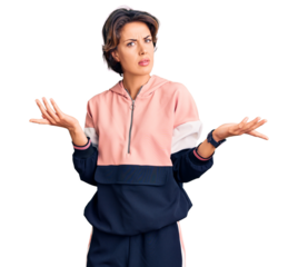 Young beautiful woman wearing sportswear clueless and confused with open arms, no idea concept.