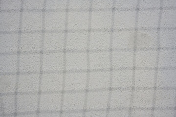 Fototapeta premium Shadows of the sports goal netting on the white wall