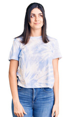 Fototapeta premium Young beautiful girl wearing casual t shirt smiling looking to the side and staring away thinking.