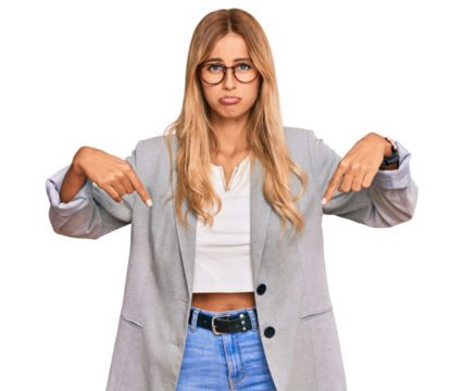 Beautiful blonde young woman wearing business clothes pointing down looking sad and upset, indicating direction with fingers, unhappy and depressed.