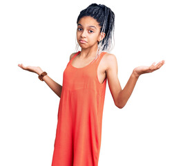 Cute african american girl wearing casual clothes clueless and confused expression with arms and...