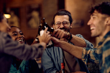 Fototapeta na wymiar Happy man and his friends toasting with beer in pub.