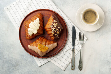 Glazed croissants on clay plate on table