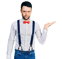 Hispanic man with beard presenting with open palm skeptic and nervous, frowning upset because of...