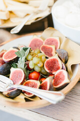 Rich bright Italian aperitif at a luxury beautiful wedding in a luxurious villa in Italy, Tuscany. Typical Italian appetizers, cheeses, ham, tomatoes and berries on the table