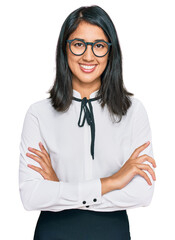 Beautiful asian young woman wearing business shirt and glasses happy face smiling with crossed arms looking at the camera. positive person.