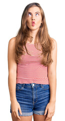 Fototapeta premium Beautiful caucasian young woman wearing casual clothes making fish face with lips, crazy and comical gesture. funny expression.