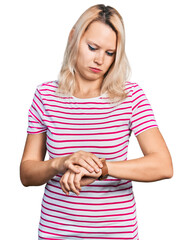 Young caucasian woman wearing casual clothes checking the time on wrist watch, relaxed and confident