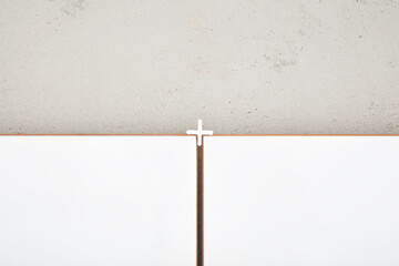Plastic cross in seam between new white ceramic tiles on light gray concrete wall or floor...