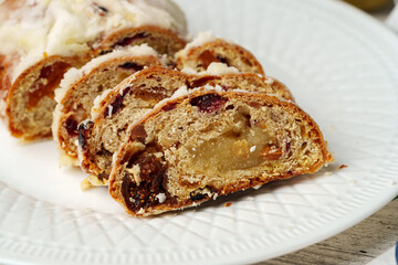 Christmas stollen on plate on white wooden table