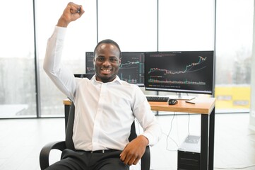African-American broker works in office using workstation and analysis technology