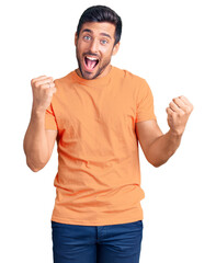 Fototapeta premium Young hispanic man wearing casual clothes screaming proud, celebrating victory and success very excited with raised arms