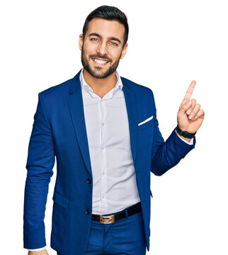 Young hispanic man wearing business jacket with a big smile on face, pointing with hand finger to the side looking at the camera.