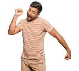 Handsome hispanic man wearing casual clothes dancing happy and cheerful, smiling moving casual and confident listening to music