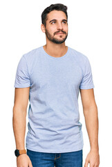 Fototapeta premium Young hispanic man wearing casual clothes smiling looking to the side and staring away thinking.