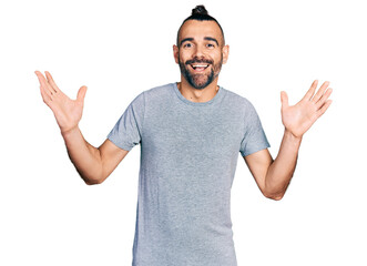 Hispanic man with ponytail wearing casual grey t shirt celebrating crazy and amazed for success...