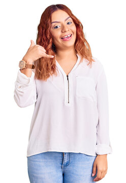 Young latin woman wearing casual clothes smiling doing phone gesture with hand and fingers like talking on the telephone. communicating concepts.