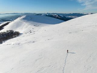 Mountaineer descending a snowy slope with snowshoes