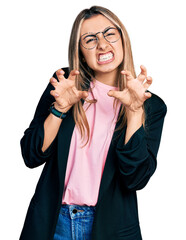 Hispanic young woman wearing business jacket and glasses smiling funny doing claw gesture as cat,...