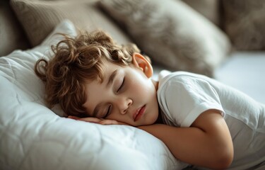 Obraz na płótnie Canvas a small boy sleeping on a white pillow