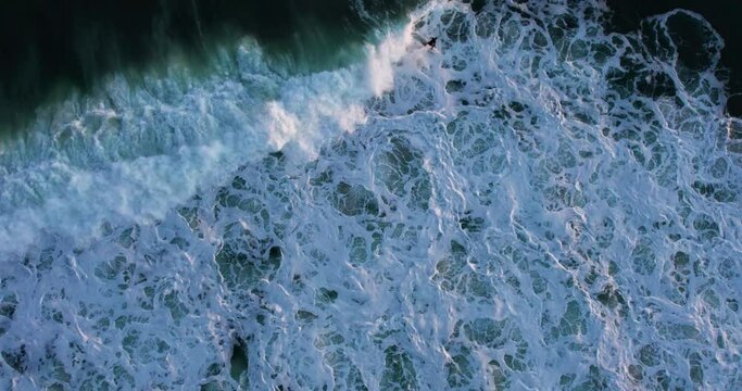 Surfer riding a wave. Overhead view of a surfer riding a wave. The aerial view gives a beautiful perspective. 