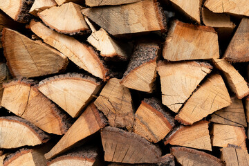 Background chopped firewood is lying in a pile stock a wall of wood preparing for winter. High quality photo