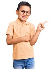 Little cute boy kid wearing casual clothes and glasses smiling happy pointing with hand and finger to the side