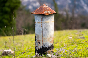 Chimney with a red top on roof of the fort on against background mountains grass and moss is an old military fortress abandoned