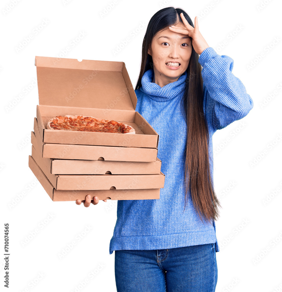 Sticker Young beautiful chinese woman holding cardboard boxes of italian pizza stressed and frustrated with hand on head, surprised and angry face