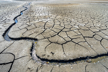 dry and cracked floor of dry river of caldera grande in the city of Barreiro with a small stream. - obrazy, fototapety, plakaty