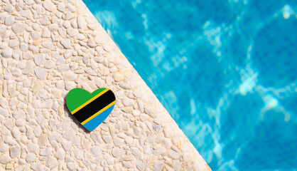 Tanzania flag in the shape of a heart near the pool in the hotel. Holiday concept in hotels