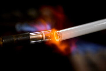 neon glass blower using fire to melt electrode to neon glass tube