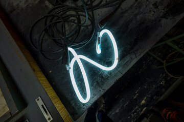 glass tube neon letter S hooked up to electricity