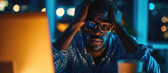 Exhausted African entrepreneur feeling overwhelmed and regretful due to work-related stress and mistakes made while working late at night in the office.