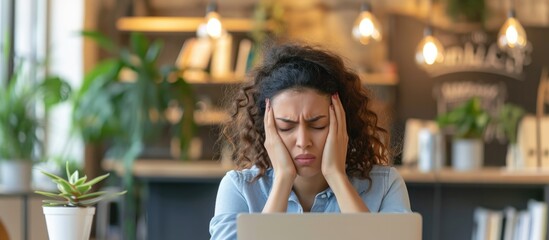 Unhappy female employee suffering from a headache at work