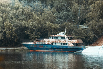 Old rusty abandoned yacht in river