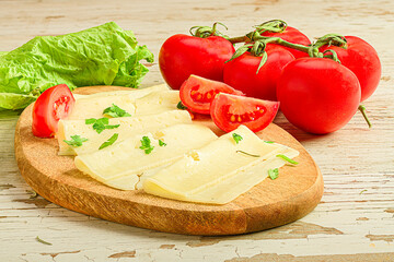some slices of cheese with some cherry tomatoes