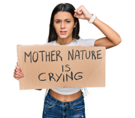 Young hispanic girl holding mother nature is crying protest cardboard banner annoyed and frustrated shouting with anger, yelling crazy with anger and hand raised
