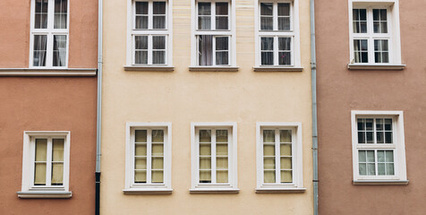 Fototapeta na wymiar The facade of house with white windows. Windows of an old typical apartment building made of panels