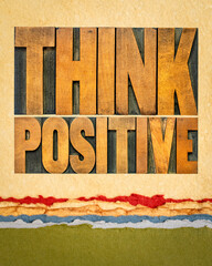 Think positive - word abstract in vintage letterpress wood type blocks on art paper, optimism and mindset concept
