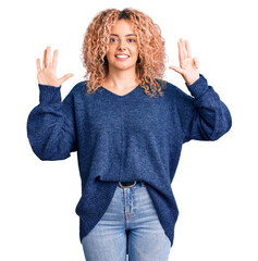 Young blonde woman with curly hair wearing casual winter sweater showing and pointing up with...