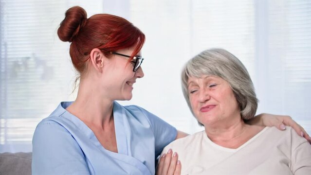 portrait of a happy female social worker with an old elderly woman, smiling and looking at camera
