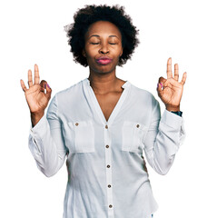 African american woman with afro hair wearing casual white t shirt relax and smiling with eyes closed doing meditation gesture with fingers. yoga concept.