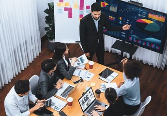 Top view business presentation with data analysis dashboard on TV screen in modern meeting room. Business people brainstorming or working together to plan business marketing strategy. Concord