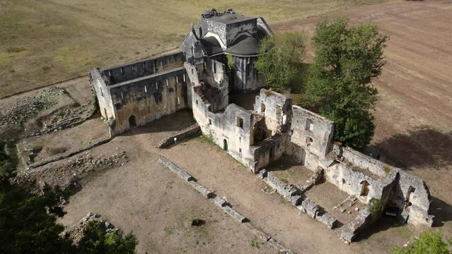 Aerial drone view of old ruins of small abbey a type of monastery used by members of a religious order under the governance of an abbot or abbess they provide a complex of buildings and land 4k