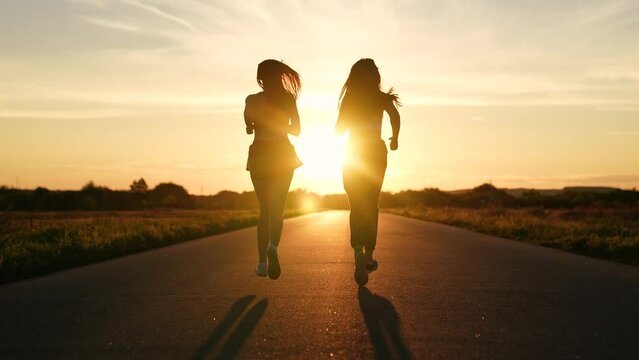 two friends running sunset, team group girls running sunset, silhouette athletic girls, teamwork runner training, sportswoman morning jogging, woman runs, running athlete, young beautiful asian