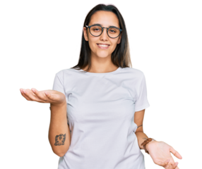 Young hispanic woman wearing casual white t shirt smiling cheerful with open arms as friendly welcome, positive and confident greetings