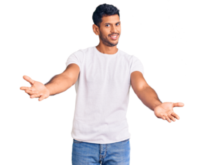 Young latin man wearing casual clothes looking at the camera smiling with open arms for hug. cheerful expression embracing happiness.