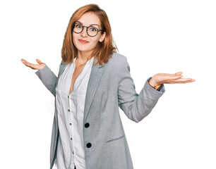 Young caucasian woman wearing business style and glasses clueless and confused expression with arms...